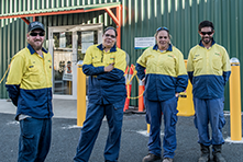 Four indigenous workers standing together outside work place