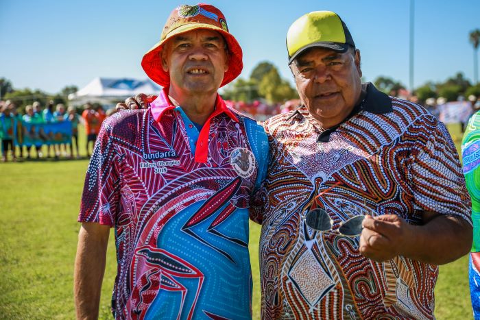 Image of two Aboriginal males in hats standing with arms around each other in Inverell in the New England and North West region