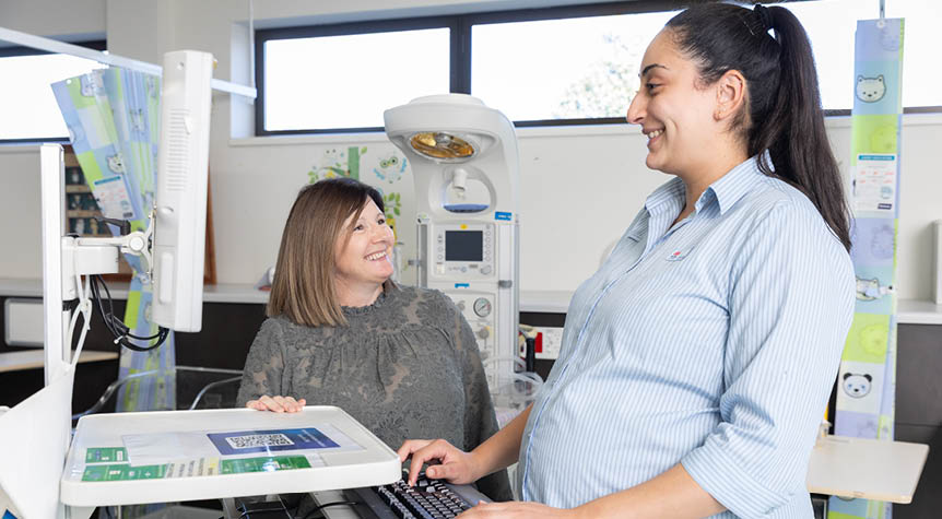A pregnant healthcare worker and a person at a hospital