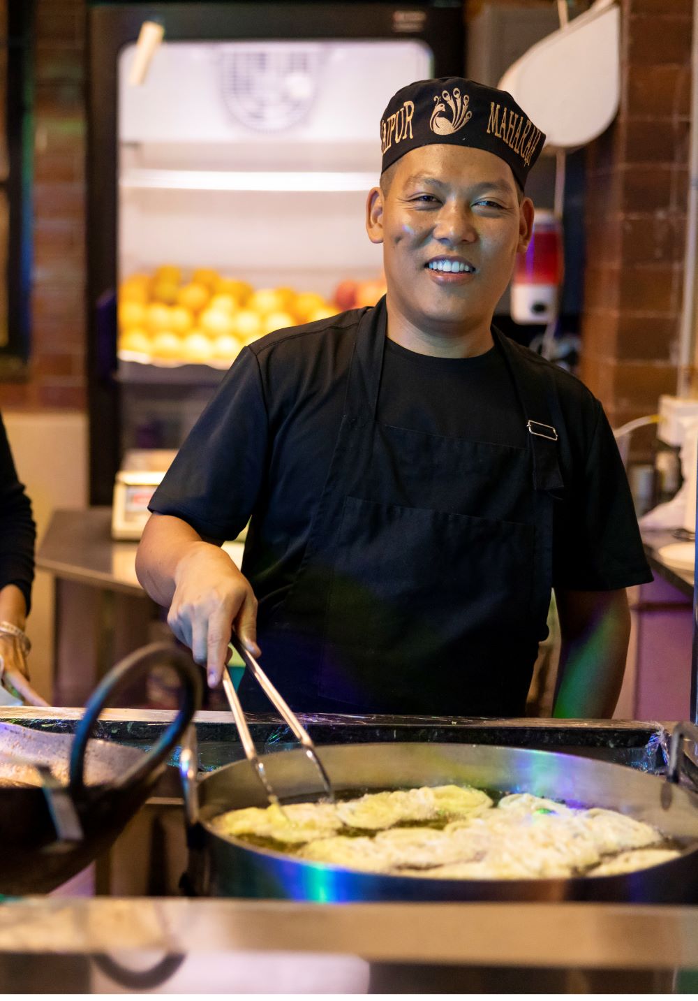 Man smiling and cooking food in oil